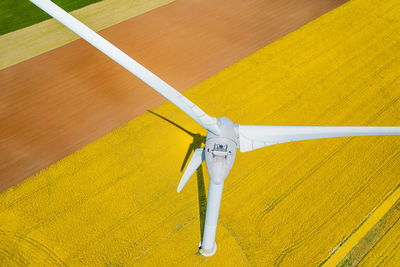 Aerial view of wind turbines farm on agricultural field in summer