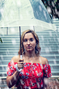 Portrait of a beautiful young woman holding umbrella