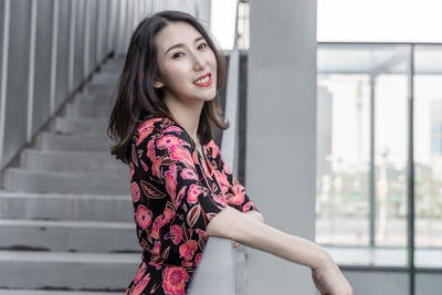 Portrait of beautiful woman standing against wall