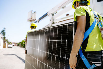 Engineers carrying solar panels on sunny day