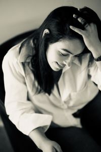 Portrait of young woman sitting on sofa at home