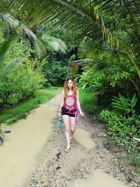 Full length portrait of woman against trees