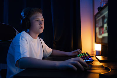 Boy playing game on computer at home