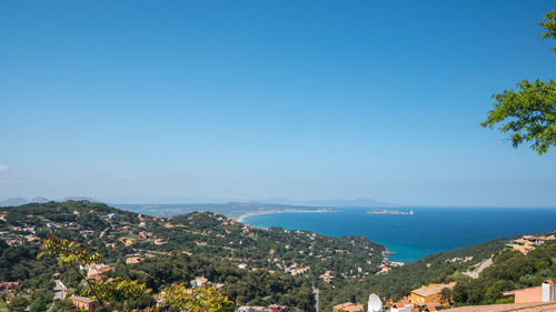 Aerial view of city by sea against sky