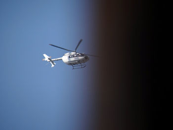 Low angle view of airplane against clear blue sky