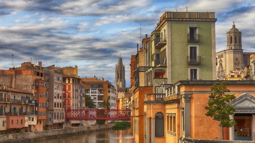 Buildings in city against cloudy sky