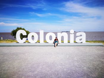 Man with text against sky in background