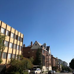 Low angle view of buildings against clear blue sky