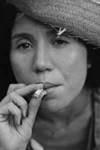 Close-up portrait of young woman smoking cigarette