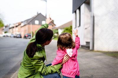 Rear view of mother and daughter in city