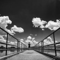 Rear view of man on bridge against sky