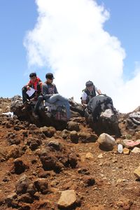 People on rock against sky