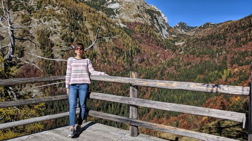 Man standing by railing against mountain