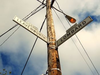 Low angle view of information sign against sky