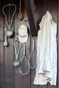 Kitchen utensils and chef coat hanging against wall