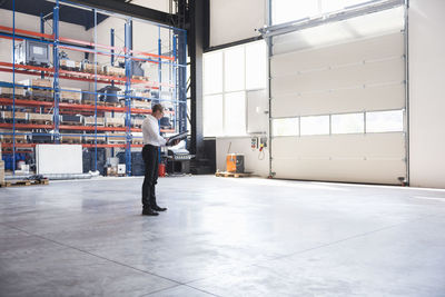 Man with documents on factory shop floor