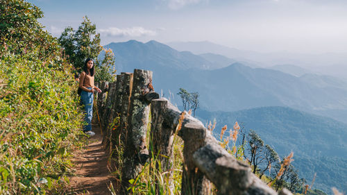 Full length of woman standing amidst plants against landscape