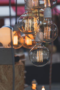 Close-up of light bulb hanging indoors