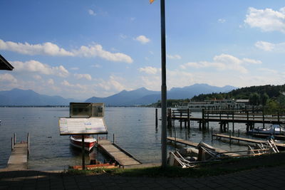 Pier on sea with mountain range in background