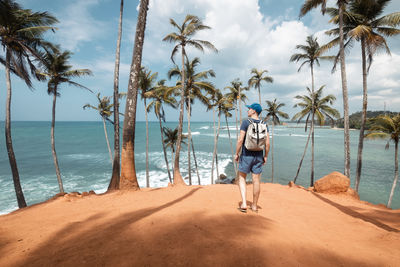 Rear view of woman walking on beach