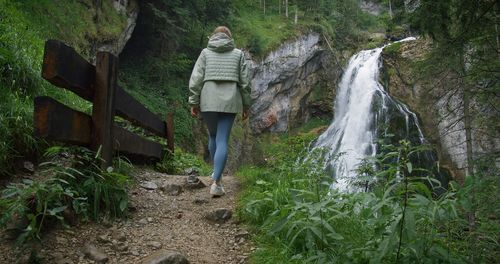 Rear view of woman standing amidst plants