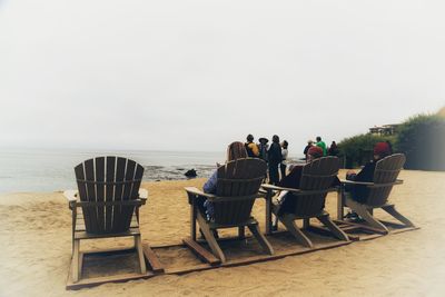 Rear view of people relaxing on beach