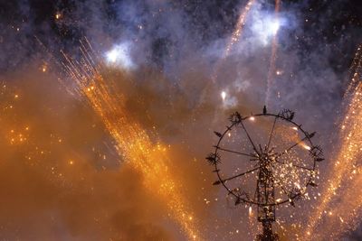 Low angle view of fireworks against sky at night