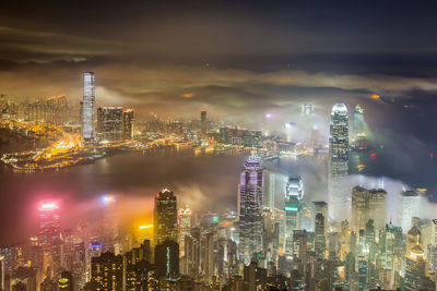 Illuminated cityscape against sky at night