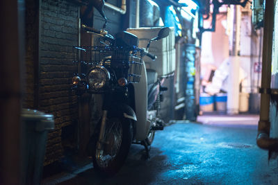 Motor scooter in alley at night