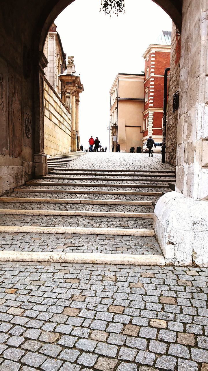 architecture, built structure, building exterior, cobblestone, steps, history, the way forward, travel destinations, clear sky, paving stone, arch, famous place, stone wall, travel, walkway, steps and staircases, tourism, day, footpath, incidental people