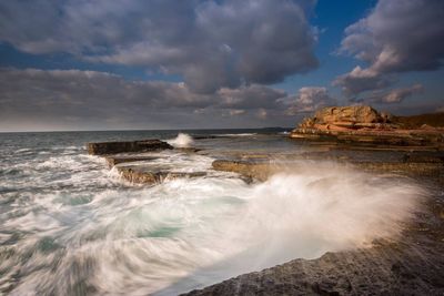 Scenic view of sea against cloudy sky