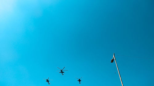 Low angle view of airplane flying against clear blue sky