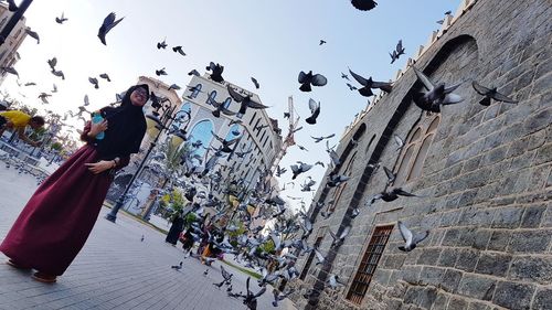 Low angle view of people flying against sky