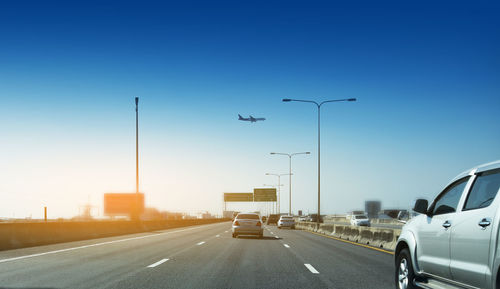 Cars moving on road against clear sky