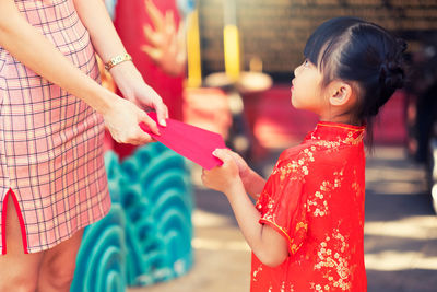 Midsection of woman holding red umbrella