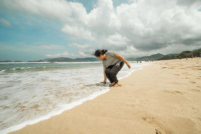 Full length of boy on beach against sky