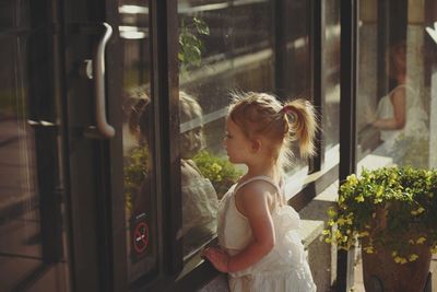 Girl looking into window glass
