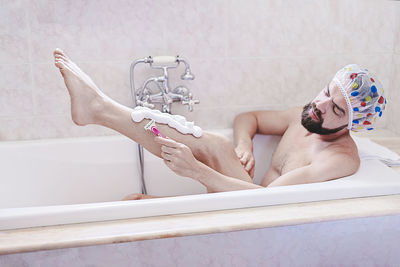 Low section of man washing hands in bathroom