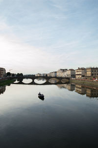 Bridge over river in city against sky