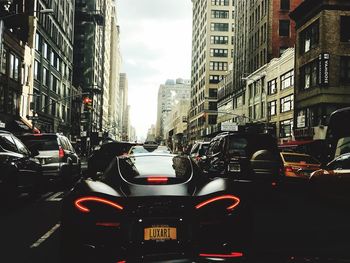 Traffic on road amidst buildings in city