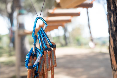 Safety harnesses hanging on string against suspension bridge at park