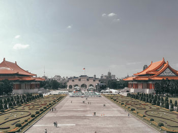 Road passing through city against sky