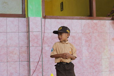 Full length of boy standing against wall