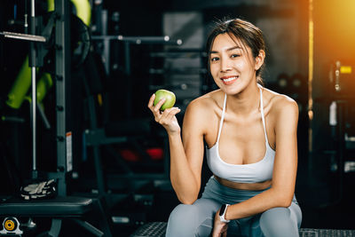 Portrait of young woman exercising in gym