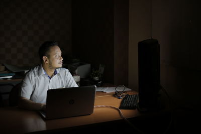 Man using mobile phone while sitting on table