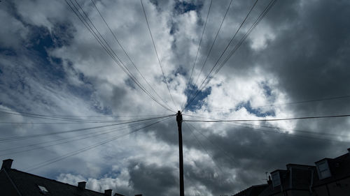 Low angle view of silhouette electricity pylon against sky