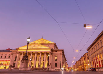 Low angle view of illuminated building against sky at dusk