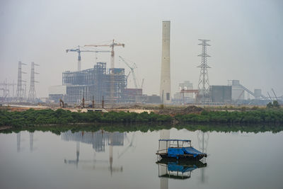 Cranes in lake against sky