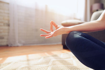 Low section of woman sitting on wooden floor