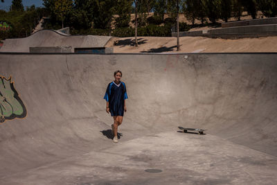 Full length of woman walking skateboard park